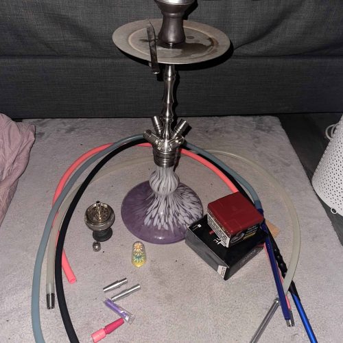 Shisha mit Glasbowl, Schlauch und Tabak, bereit zum Rauchen.