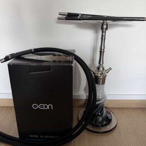 Shisha mit Glasbowl, Schlauch und Verpackung auf Holzboden.