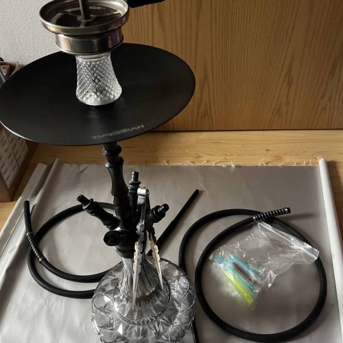Wasserpfeife mit Glasbasis, Schlauch und Tabakkopf, ideal für Shisha-Liebhaber.