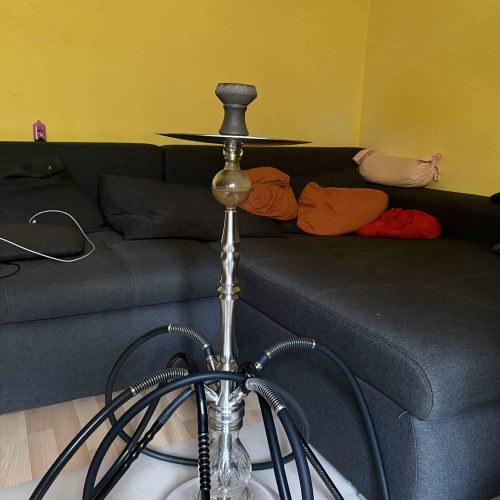 Shisha-Kopf mit Glasbowl und Schläuchen auf Tisch.