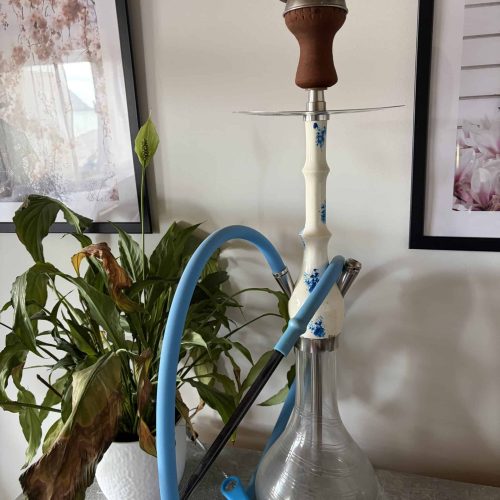 Shisha-Kopf mit Glasbowl und Schlauch auf Tisch.