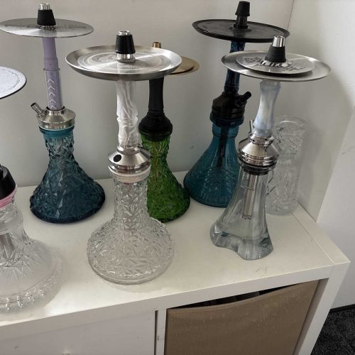 Mehrere Wasserpfeifen in unterschiedlichen Farben und Designs, ideal für Shisha-Liebhaber.