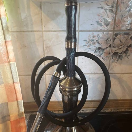 Shisha mit Metallkörper und schwarzem Schlauch, bereit zum Rauchen.