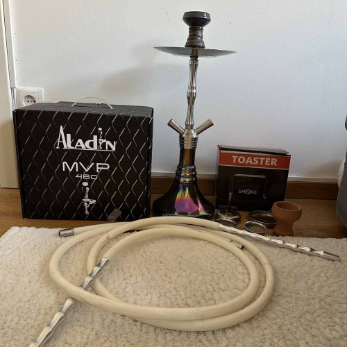 Shisha mit Schlauch, Kohleteller, Verpackung und Zubehör auf Teppich.