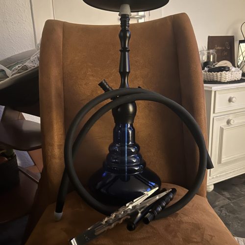 Shisha mit Glasbowl und Schlauch auf Stuhl.