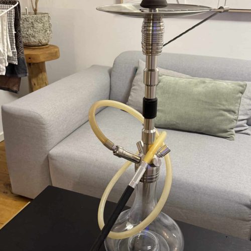 Moderne Shisha auf Tisch mit Rauchsäule im Wohnzimmer.
