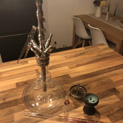 Rauch-Hookah mit Glasbasis, Tabak, Zange und Kohle.