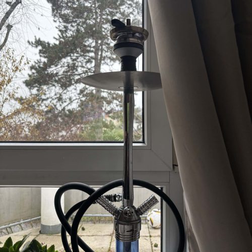 Shisha-Rauchsäule vor einem Fenster mit Blick nach draußen.