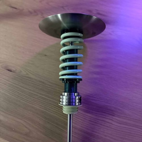 Shisha-Glasbowl mit Metallbasis und Spiralstütze auf Holztisch.