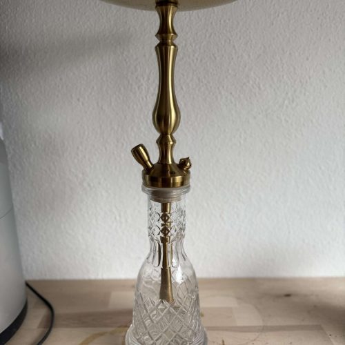 Schmuckhaken mit goldener Halterung und Glasbasis, ideal für Dekoration oder Aufbewahrung.