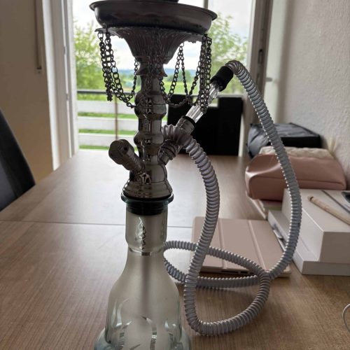 Rauchende Wasserpfeife mit Wasserbehälter und Schlauch, ideal für Shisha-Liebhaber.