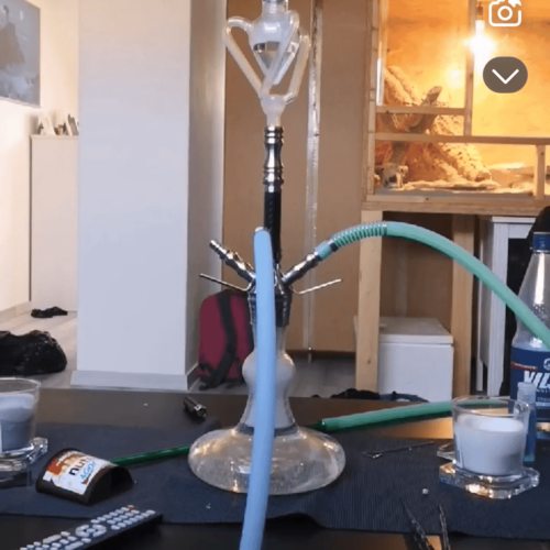 Shisha mit Glasbowl, Schlauch und Zubehör im Raum.