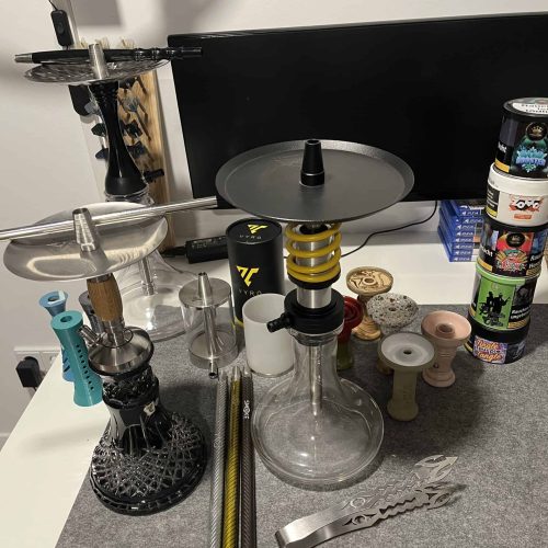 Shisha-Zubehör und Raucherset auf Schreibtisch, diverse Teile sichtbar.