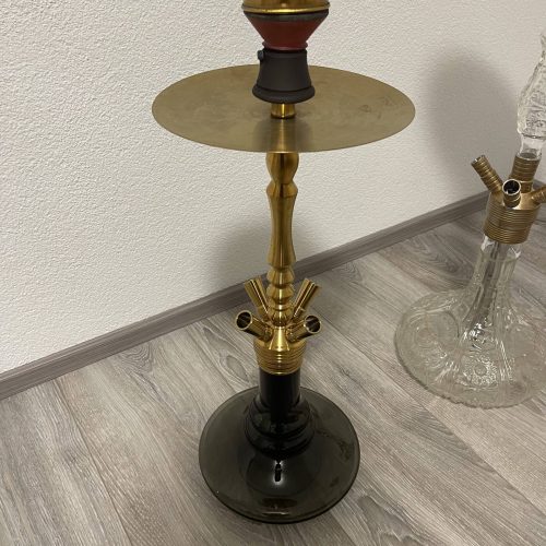 Schwarze Shisha mit goldenen Akzenten und Ablagefläche.