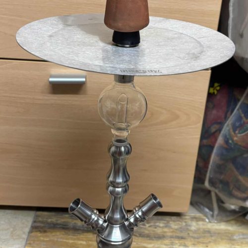 Shisha-Kopf mit Glasbowl auf einem Tisch.