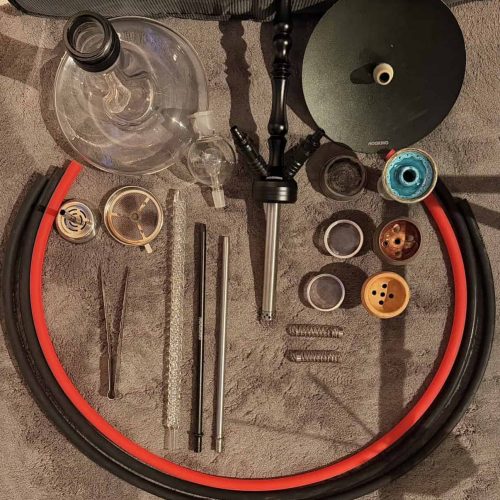 Verschiedene Shisha-Teile und Zubehör auf einem Tisch.