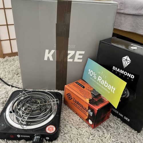Elektrische Shisha mit Zubehör, Verpackung und Rabattgutschein.