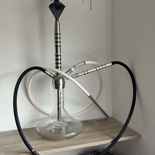 Shisha mit Glasbowl, Heizplatte und Schlauch auf Holzregal.
