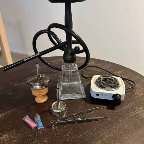 Shisha-Zubehör mit Kohle, Tabak und Zubehör auf Tisch.
