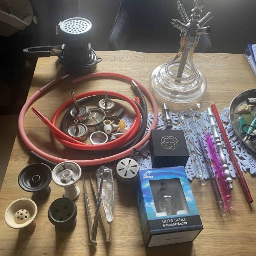 Verschiedene Shisha-Teile und Zubehör auf einem Tisch.