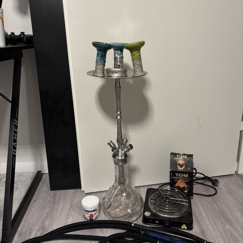 Shisha-Set mit Glasbowl, Schlauch und Heizplatte auf Boden.