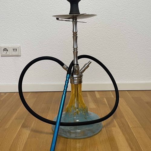 Shisha mit Glasbowl, Schlauch und Kopf auf Holzboden.
