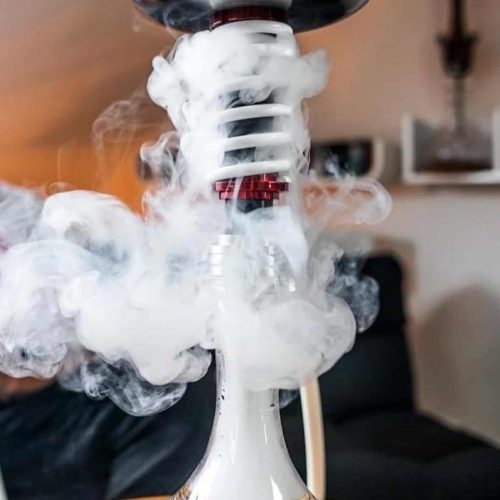 Shisha mit Rauchentwicklung und LED-Beleuchtung, auf Holztablett präsentiert.