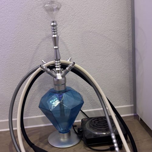 Moderne Shisha mit Glas-Kopf und Zubehör, bereit zum Rauchen.