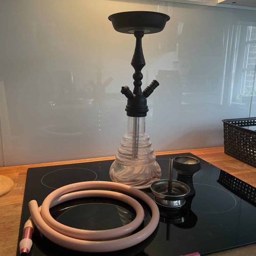 Raucherset für Shisha mit Glasbowl, Schlauch und Zubehör auf einer Küchenarbeitsplatte.