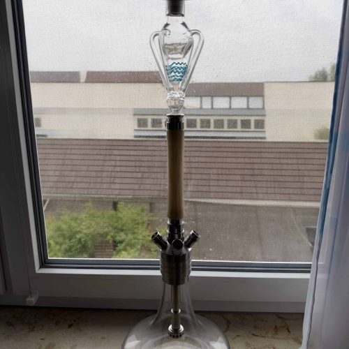 Shisha mit Glasbowl und Holzstamm, Blick durch Fenster.