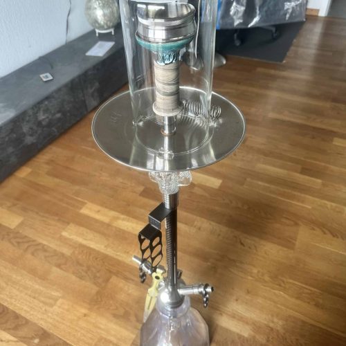 Große Shisha mit Glasbowl und Metallständer auf Holzboden.