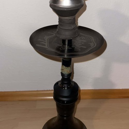 Moderne schwarze Shisha mit Metall- und Kunststoffkomponenten, auf Holzboden stehend.