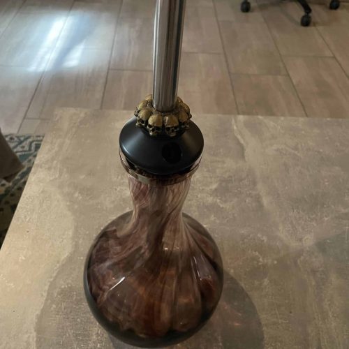 Holzständer für Shisha mit Metallrohr, auf Tisch stehend.
