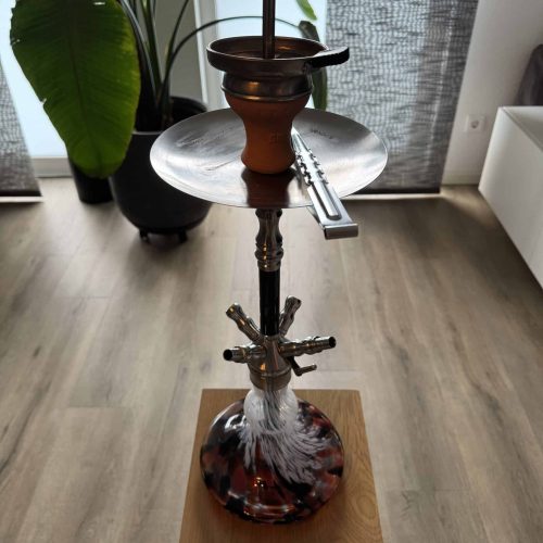 Rauchsäule mit Wasserpfeife, Tabak und Zubehör auf einem Tisch. Perfekt für Shisha-Liebhaber, die ei.