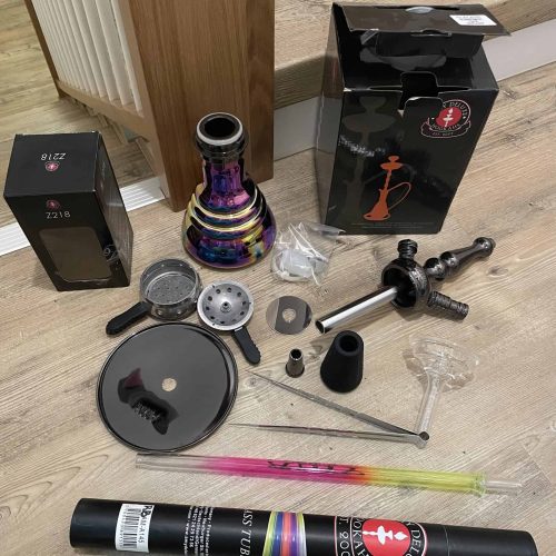 Verschiedene Teile und Zubehör für eine Shisha, inklusive Rauchsäule, Dichtungen und Schlauch.