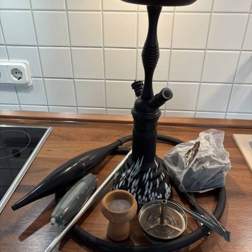 Raucherset für Shisha mit Schlauch, Kohlezange und Zubehör auf Holzarbeitsplatte.