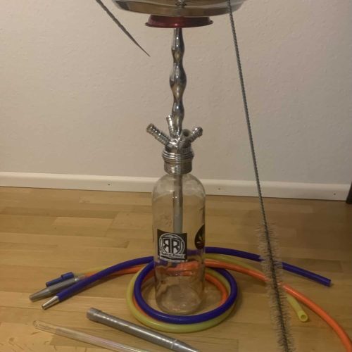 Rauchende Shisha mit Glasflasche, Schläuchen und Zubehör für Wasserpfeifen.