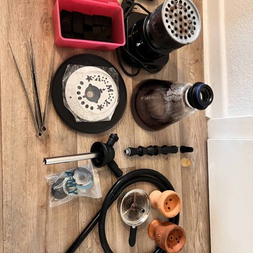 Verschiedene Shisha-Teile, Kohle, Schlauch und Zubehör im Set.
