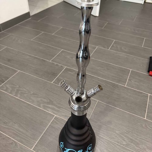 Shisha mit Edelstahlrohr und schwarzer Basis, auf Holzboden stehend.