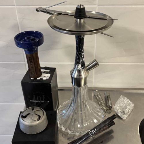 Shisha mit Zubehör, Tabak und Feuerstein auf Tisch.
