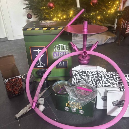 Halter für Wasserpfeife in Pink, inklusive Zubehör und Verpackung, auf einem Tisch vor einem Weihnac.