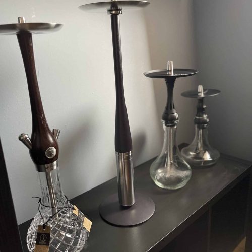 Verschiedene Wasserpfeifen in Holz und Glas auf Regal, Shisha-Modelle zum Verkauf.