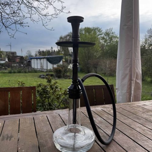 Wasserpfeife (Shisha) mit Glasbasis und schwarzem Schlauch im Freien.