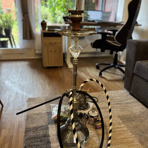 Hookah mit Schlauch und Tabak im Wohnzimmer, entspannte Atmosphäre.