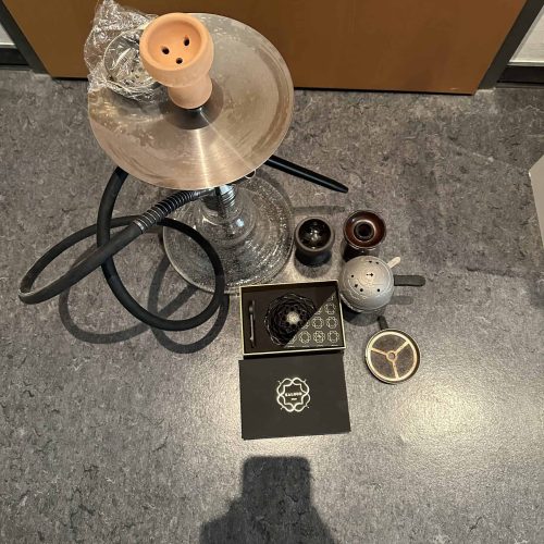 Shisha-Zubehör mit Kopf, Schläuchen und Tabak.