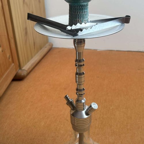 Shisha mit Glasbowl, Schlauch und Dichtung auf Holztisch.