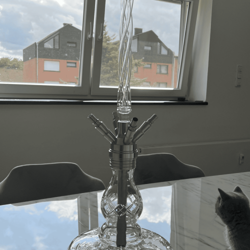 Moderne Glas-Shisha auf Tisch mit Blick aus dem Fenster.