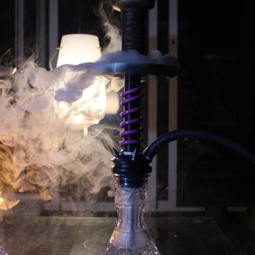 Schwarze Shisha mit Glasbowl und Rauchentwicklung im dunklen Raum.