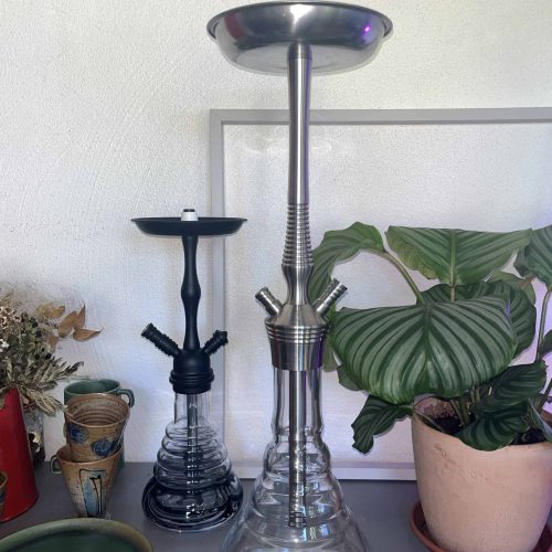 Moderne Shisha mit Edelstahlrohr und Glasbowl auf Tisch.