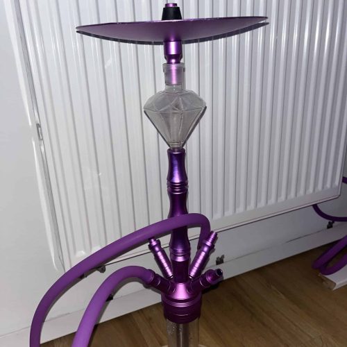 Lila Shisha mit Glasaufsatz vor Heizkörper.